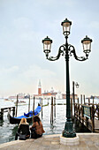Venice, Italy. Two women sitting on the waterfront at the St. Mark´s square (Piazza San Marco).