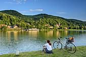 Woman cycling sitting at Danube, Danube arm at Altenberg, Altenberg, Danube Bike Trail, Lower Austria, Austria