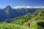 Woman ascending to Brechhorn, Grosser Rettenstein with Grossvenediger in background, Brechhorn, Kitzbuehel Alps, Tyrol, Austria