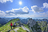 Woman and man ascending to Kraehe, Saeuling, Tegelberg and Gabelschrofen in background, Kraehe, Ammergau Alps, East Allgaeu, Allgaeu, Swabia, Bavaria, Germany