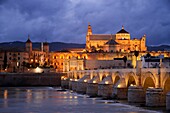 Spain, Andalusia (Andalucia), Cordoba, historic centre listed as World Heritage by UNESCO, the Roman bridge over Guadalquivir river and the Mosque Cathedral (Mezquita) at dusk.