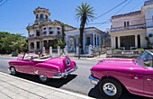 Havana Cuba pink classic 1950s auto in beautiful neighborhood of Habana parked.