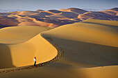 Woman in the sand dunes of the empty quarter desert. United Arab Emirates, UAE, Abu Dhabi, Liwa Oasis, Moreeb Hill, Tal Mireb. Model Released.