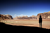 Silhouette of a woman and red sand desert from Jebel Qattar. Jordan, Wadi Rum desert, protected area inscribed on UNESCO World Heritage list. Model Released.