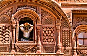 Jodhpur at Fort Mehrangarh in Rajasthan India man in window of Fort Palace in costume