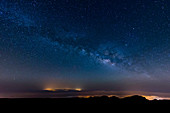The Milky Way arcs above the city lights of Las Palmas De Gran Canaria, Canary Islands, Spain, Europe