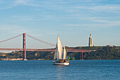 Sailboat navigating on the Tagus River near the Ponte 25 de Abril, Belem, Lisbon, Portugal, Europe