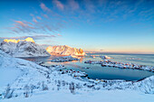 The colors of dawn frame the fishing villages surrounded by snowy peaks, Reine, Nordland, Lofoten Islands, Arctic, Norway, Scandinavia, Europe