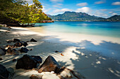 A deserted Seychelles beach with the calm still waters of the Indian Ocean beyond, Seychelles, Indian Ocean, Africa