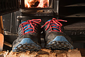 Tral running shoes dry outside wood burning stove at Sälka hut after wet day of hiking, Kungsleden trail, Lapland, Sweden