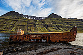 'Old shipwreck along the water in Mjoifjordur, East Iceland; Iceland'