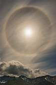 A 22 degree halo fills the sky over the Chigmit Mountains within Lake Clark National Park & Preserve, Alaska.