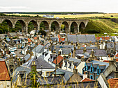 'Rooftops of houses and an old stone bridge with arches; Cullen, Moray, Scotland'