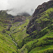 'Clouds lying low over rugged and foliage covered mountains; Scotland'