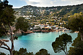 'Turquoise water in a lake with houses on a hillside; Gerone, Catalonia, Costa Brava, Spain'