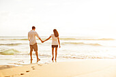Happy Romantic Couple Walking on the Beach Enjoying the Sunset