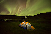 'Tent lit up at night in front of the waterfall Dynjandi; West Fjords, Iceland'