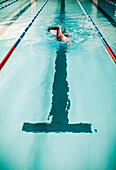 Man Swimming in Indoor Swimming Pool