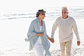 Couple walking on the beach with holding hands of each other