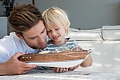 Happy father and son with a model boat