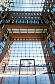 Der Innenhof des Bürohauses Elbflorenz an der Großen Elbstrasse im alten Holzhafen mit Blick auf Containerkräne, Hamburg, Deutschland