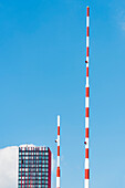 The poles for the bridge flanking the high rise building Red Apple in the background, Rotterdam, Netherlands