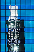 A high-rise office block reflected in the glass facade of another high rise building in the city centre, Rotterdam, Netherlands