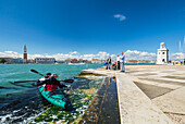 A kayak leaves San Giorgio Maggiore island. Venice, Veneto, Italy.