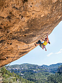 Mixed Race girl climbing rock