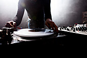 Caucasian disc jockey playing music in nightclub