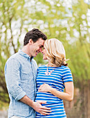 Smiling Caucasian man and expectant mother rubbing noses