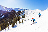Couple skiing on snowy mountain slope
