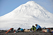 Skiers gear up on the beach of Augustine Island in Cook Inlet, Alaska. The men and women skiers prepare for an ascent of Mt Augustine, the 4,025-foot high active volcano that dominates the island.