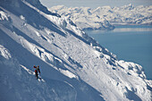 Skiers descend from the summit of  Mt Augustine, a 4,025-foot high active volcano on Augustine Island in Cook Inlet, Alaska. The run back to the coast line includes boulders covered in rime ice and soaring volcanic towers. The lava dome volcano is part of