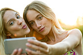 Couple posing cheek to cheek for smartphone selfie