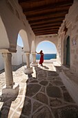 Woman standing near the columns of the main church in Parikia, Paros, Cyclades Islands, Greek Islands, Greece, Europe.