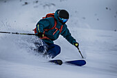 Young male skier riding through deep powder snow apart the slope, Andermatt, Uri, Switzerland