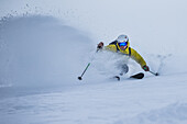 Junger Skifahrer fährt duch Tiefschnee abseits der Piste, Andermatt, Uri, Schweiz