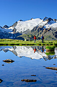 Woman and man hiking at mountain lake, Oetztal Alps in background, lake Soomsee, Obergurgl, Oetztal Alps, Tyrol, Austria