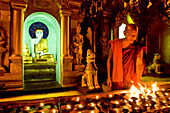Myanmar (Burma), Yangon Division, Yangon, Kandawgyi District, Park of the People, Swhedagon Pagoda (Paya Shwedagon), monk MSyriya lighting candles