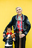 Mexico, Federal District, Mexico City, Coyoacan district, a young Mexican and his great-uncle dressed in traditional mariachi