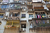 Wäsche hängt von Geländern an Balkonen von einem Apartmentgebäude, Macau, Macau, China