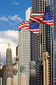 USA, Illinois, Chicago, an der Unterseite Büsten von Geschäftsleuten von Merchandise Mart, amerikanische Flaggen und im Hintergrund die Wolkenkratzer von West Wacker Drive