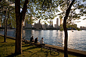 United States, Illinois, Chicago, Gold Coast and buildings at the edge of Michigan Lake in sunset from Olive Park, cycliste and their bikes