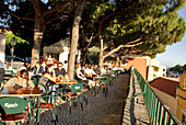 Portugal, Lisbon, Graca District, people sitting down at table on the Miradouro de Graca Terrace