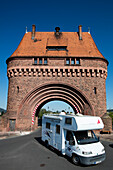 Motorhome passes through Torhaus town gate on Mainbruecke bridge across Main river, Miltenberg, Spessart-Mainland, Bavaria, Germany