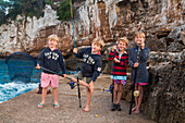 Kinder versuchen ihr Glück beim Angeln an der Cala Llombards Bucht, nahe Santanyi, Mallorca, Balearen, Spanien