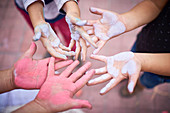 Hands of children covered in multicolor chalk
