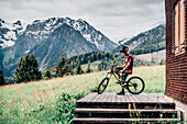 Portrait junger Mountainbiker, Mountainbike, Hütte, Brandnertal, Vorarlberg, Österreich