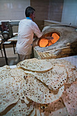 Traditional baker at work at his oven, Ramsar, Iran, Middle East